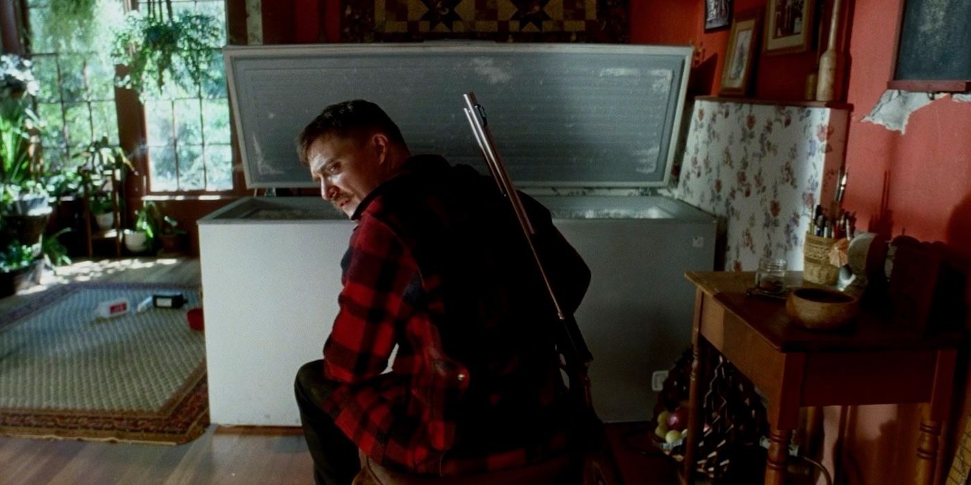 Kyle Gallner as The Demon looking in an ice chest in Strange Darling