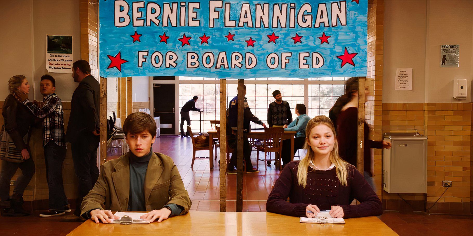 Bernard y Verónica están en una mesa con carpetas en el aula.