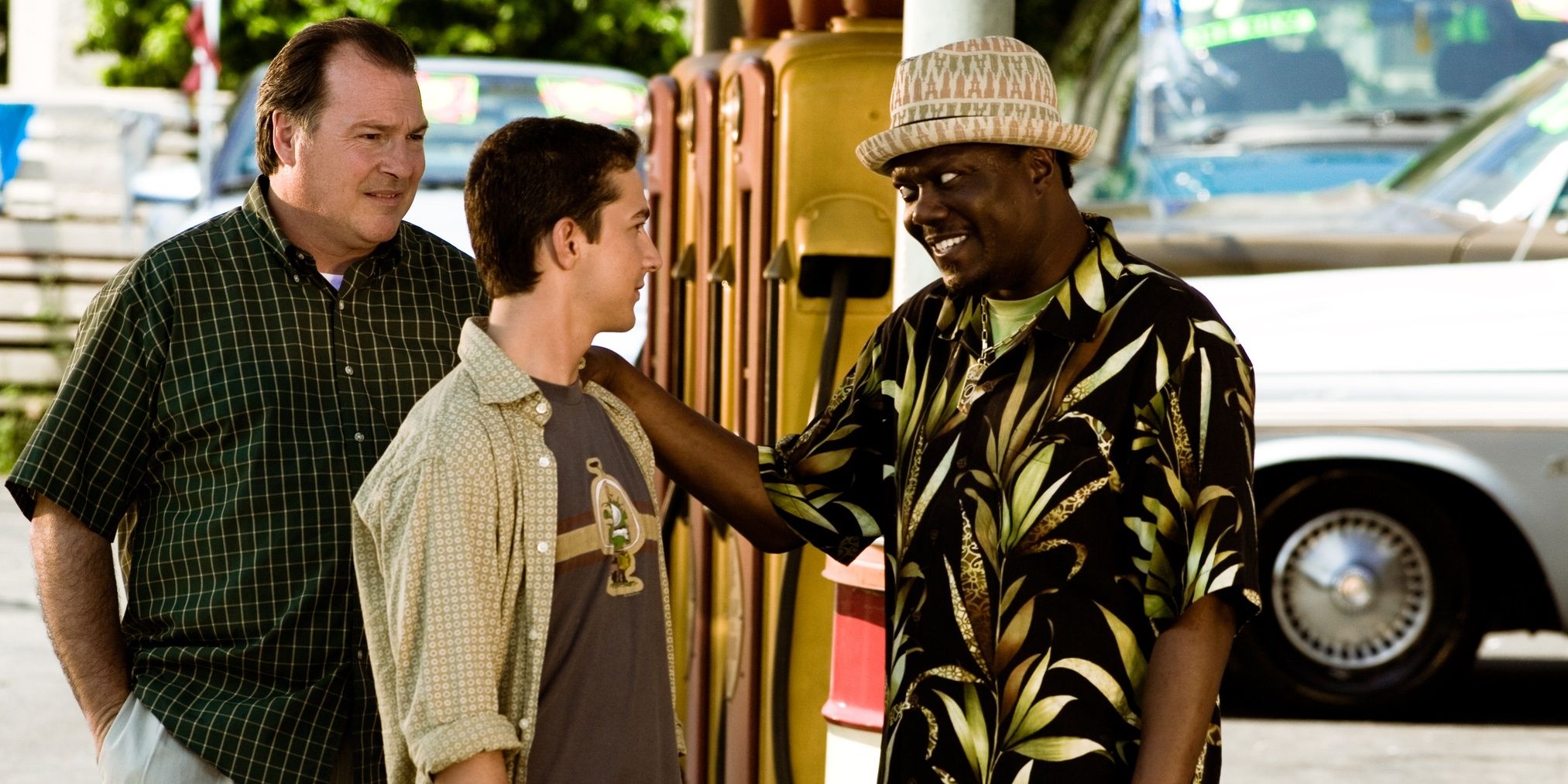 Um vendedor de carros (Bernie Mac) coloca as mãos no ombro de Sam Witwicky (Shia LaBeouf) em Transformers (2007)