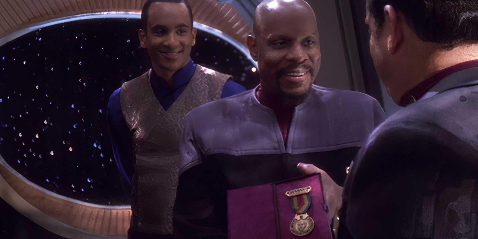 Captain Benjamin Sisko (Avery Brooks) receives the Christopher Pike Medal of Valor as Jake Sisko (Cirroc Lofton) watches in DS9 Tears of the Prophets