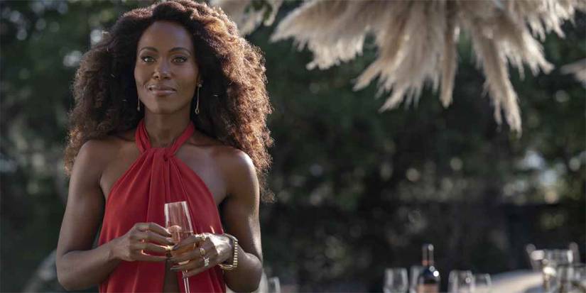 Sloane (DeWanda Wise) in red dress on outside party in Three Women