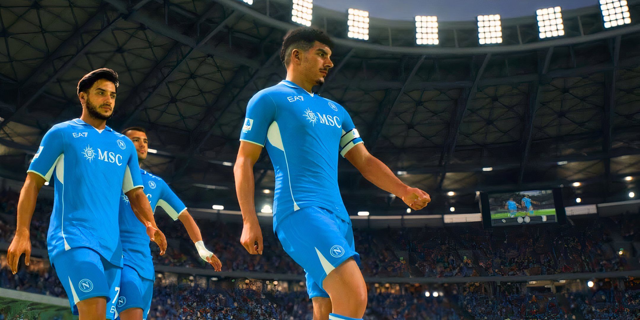 A screenshot from EA FC25 shows Napoli players walking around the pitch in their home kit. The players prepare for the start of the match in a large, brightly lit stadium