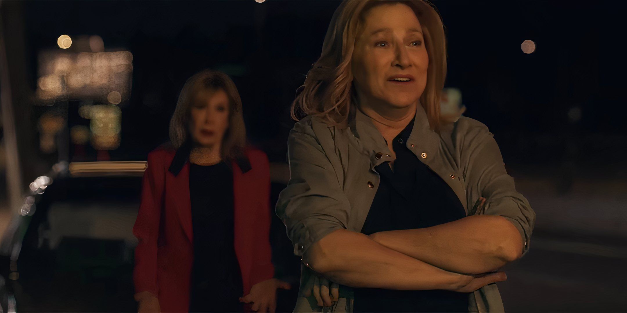 Edie Falco como Wanda parecendo angustiada com sua mãe ao fundo em I'll Be Right There