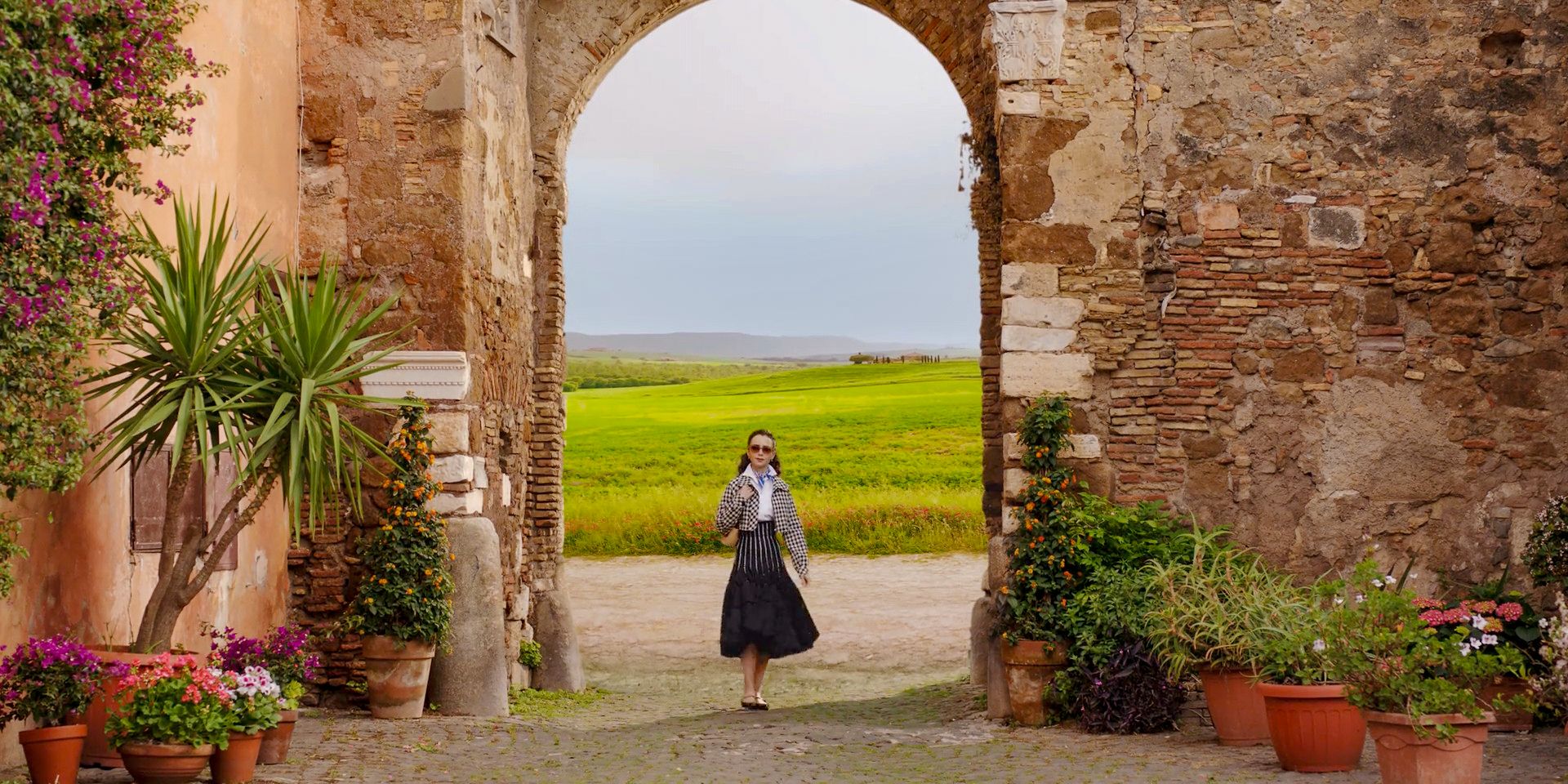 Emily walking through an arch in Emily in Paris Season 4 Episode 10