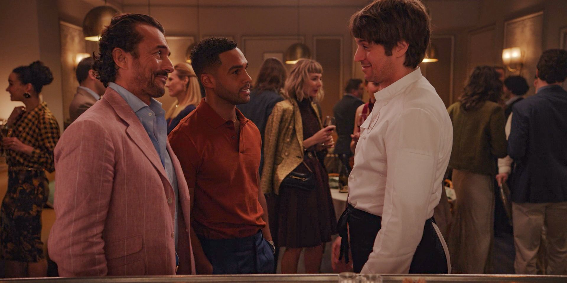 Antoine (William Abadie) and Alfie (Lucien Laviscount) congratulating Gabriel (Lucas Bravo) on winning the Michelin star in Emily in Paris Season 4 Episode 10