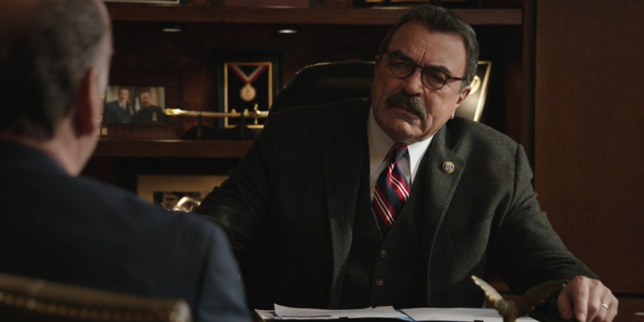 Frank sits across from Sid at his desk looking unhappy on Blue Bloods