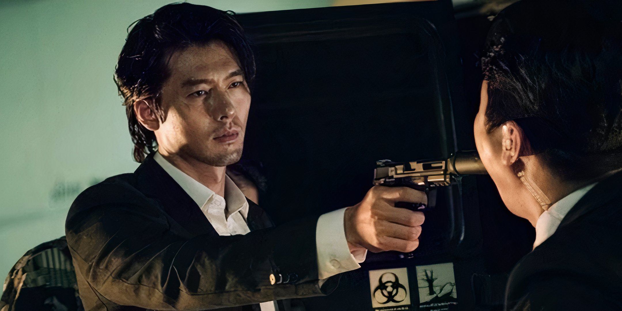 Hyun Bin points a gun at another man's face.