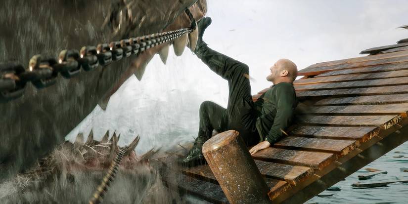 Jason Statham holds a sharks jaws open in Meg 2