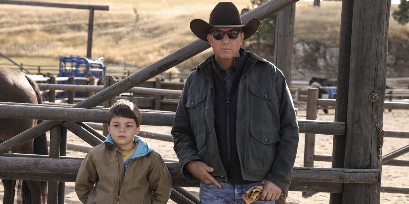 John (Kevin Costner) sand Tate (Brecken Merrill) leaning against a fence in Yellowstone.