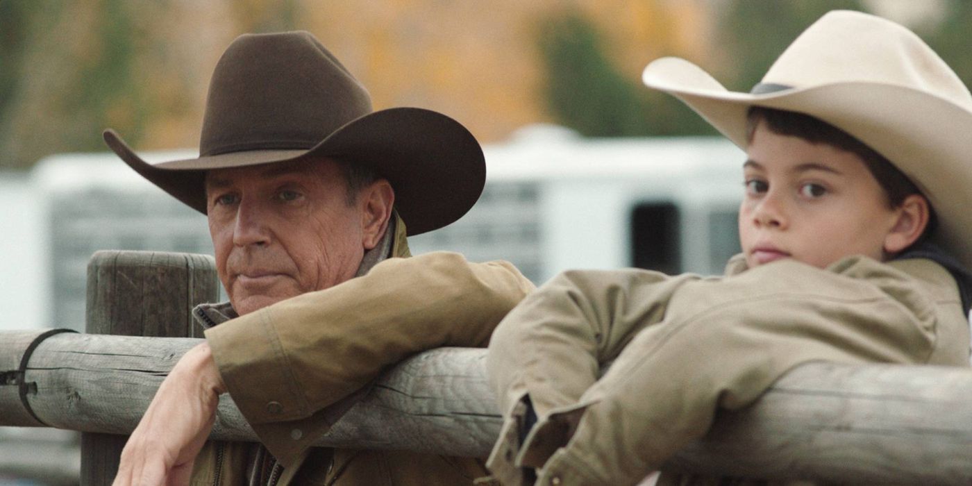 John (Kevin Costner) sand Tate (Brecken Merrill) looking over a fence together in Yellowstone.