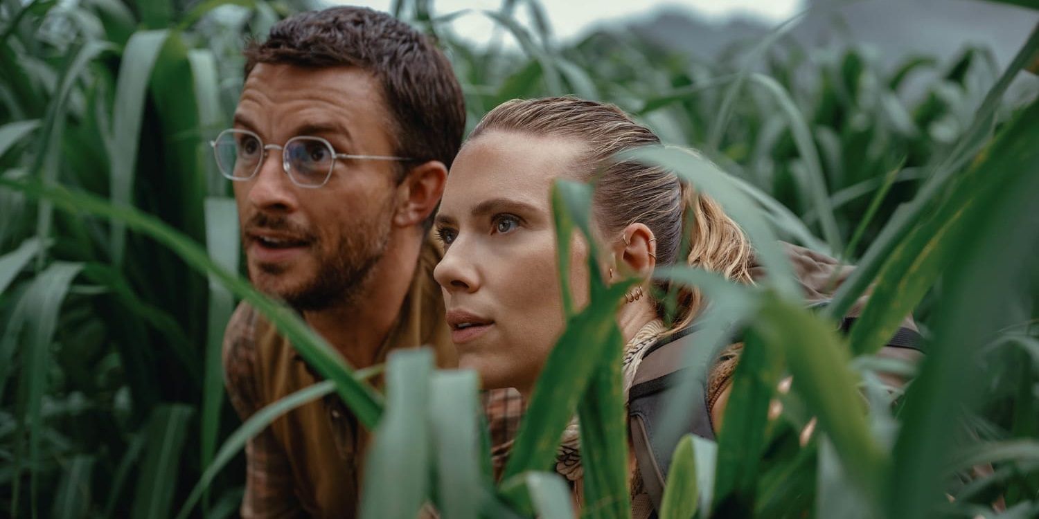 Jonathan Bailey and Scarlett Johansson in the tall grass in Jurassic World Rebirth