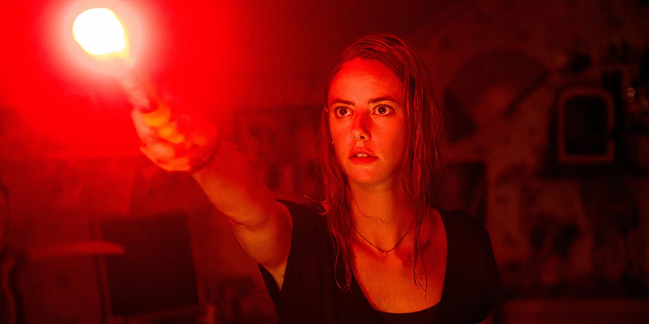 Kaya Scodelario as Haley holding up a flare in Crawl