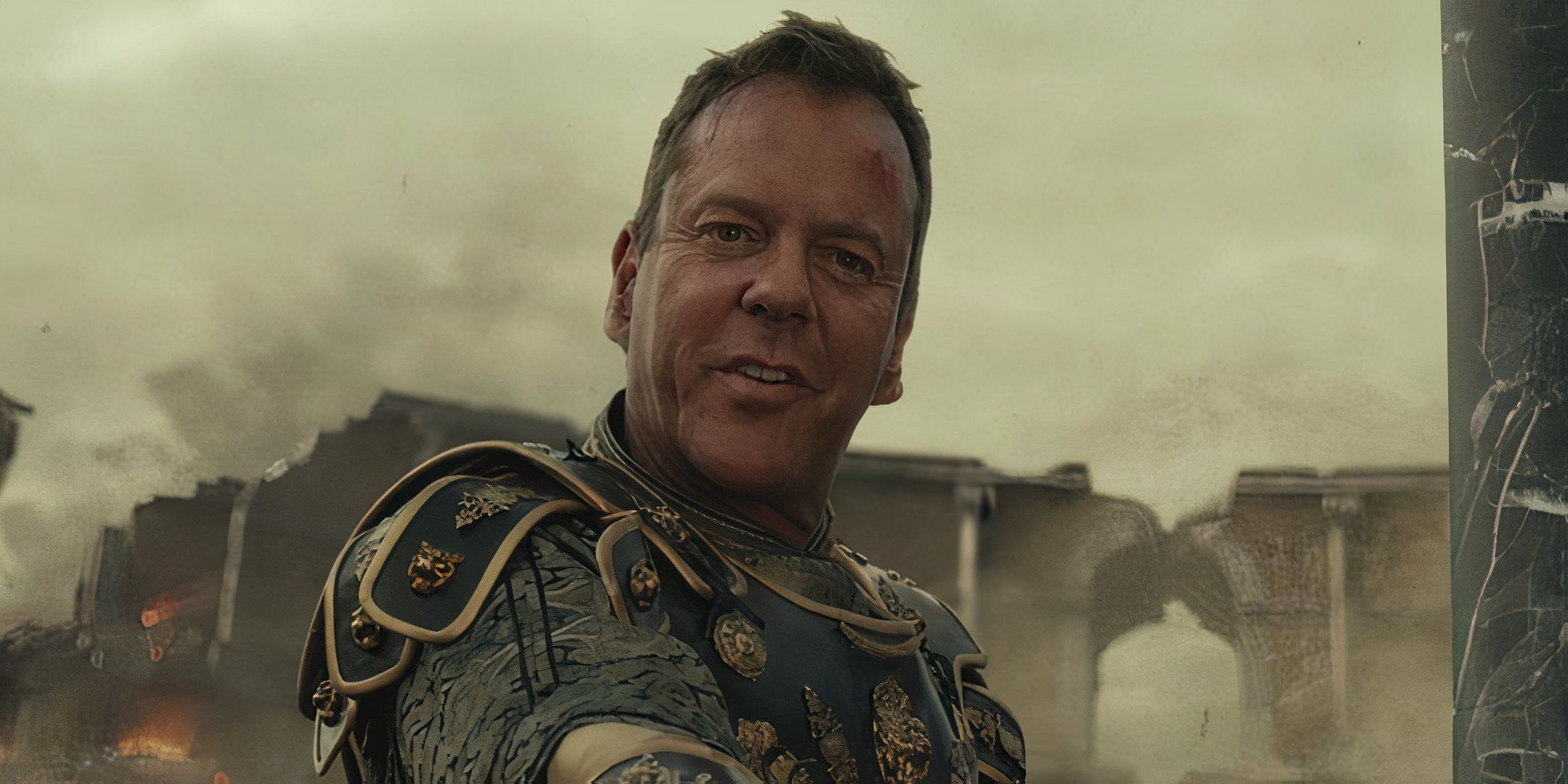 Kiefer Sutherland looks forward with a slight smile on his face. 