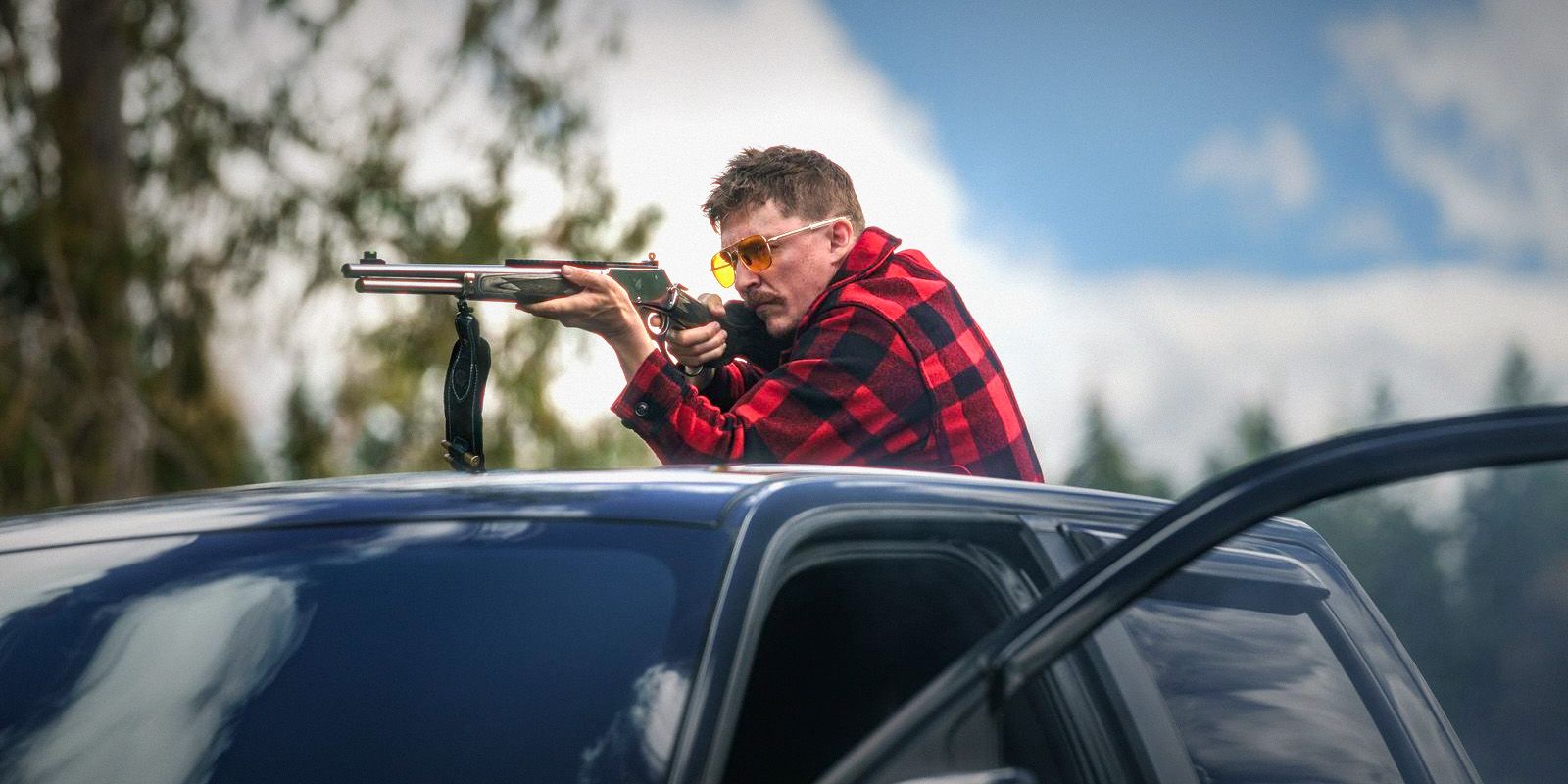 Kyle Gallner como un demonio apuntando con un rifle desde lo alto de su camioneta en Strong Darling.