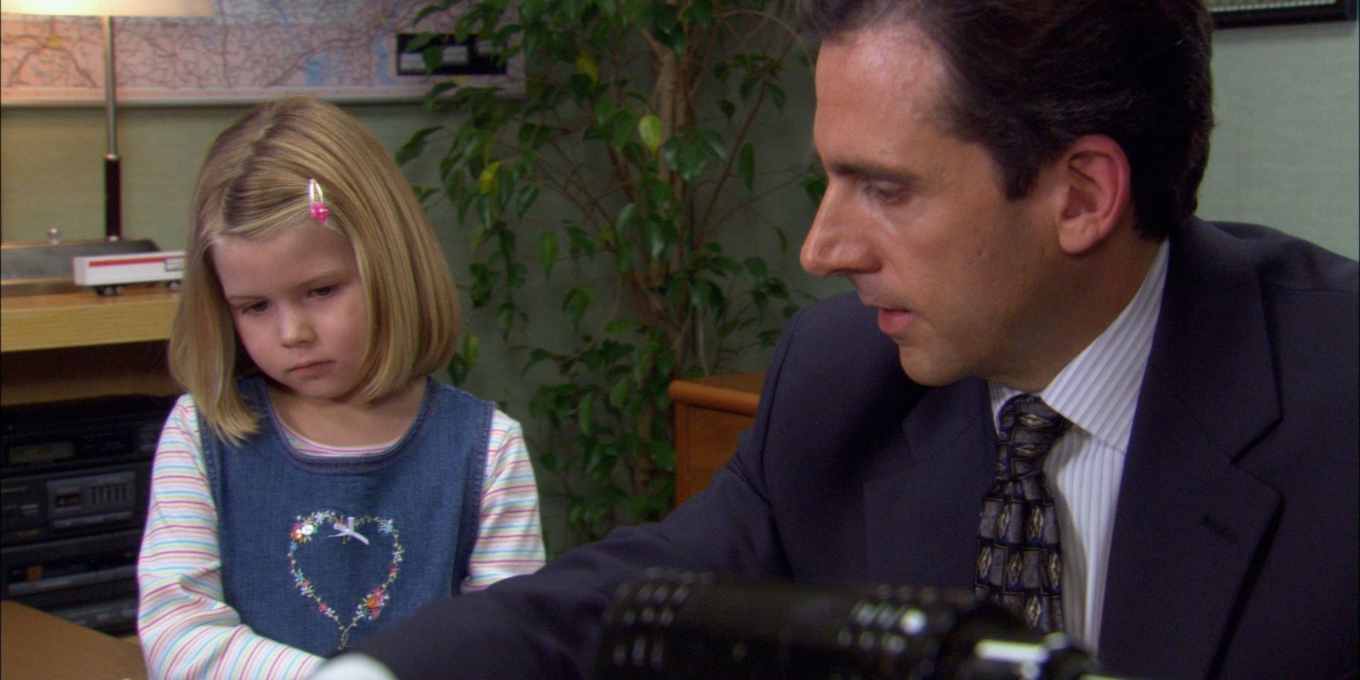 Michael in his office with Toby's daughter in The Office