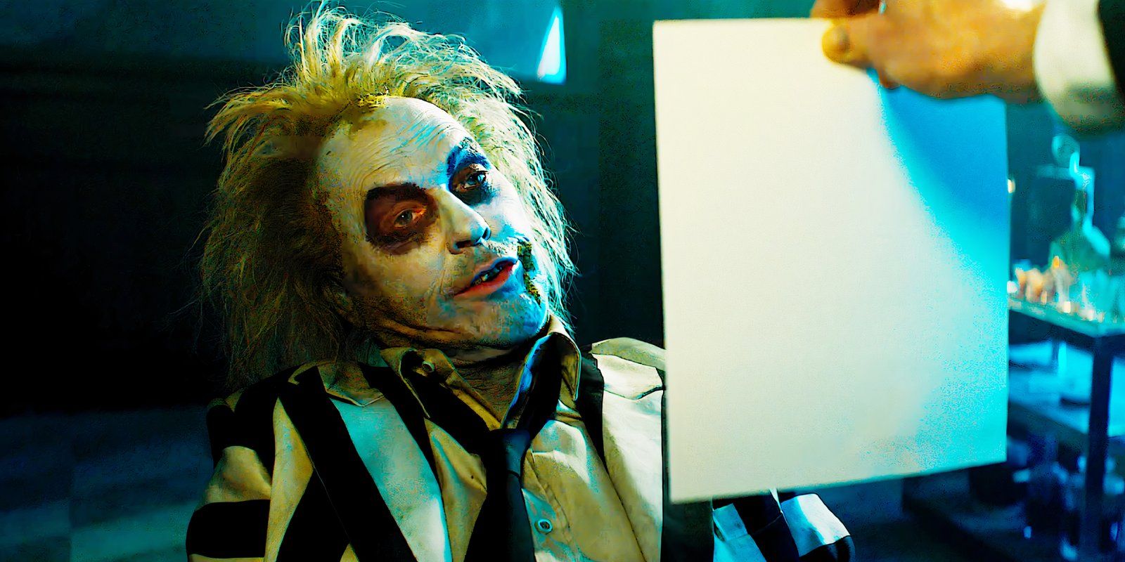 Michael Keaton dans le rôle de Beetlejuice regardant un morceau de papier dans Beetlejuice Beetlejuice