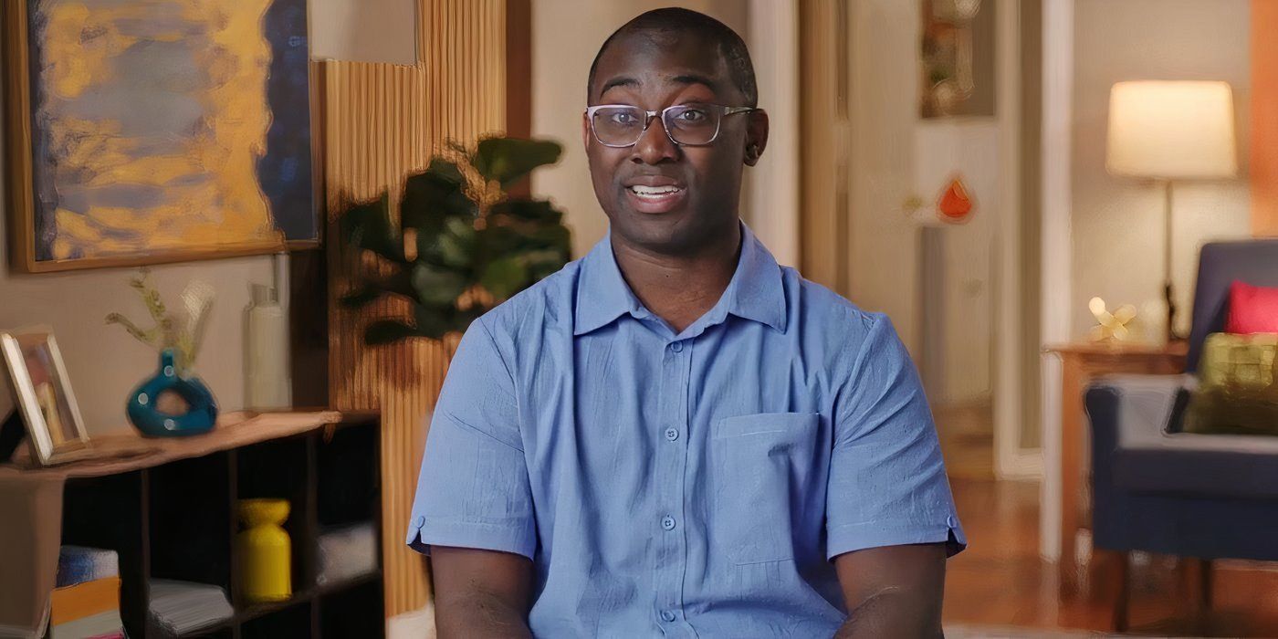 Niles Valentine In 90 Day Fiance in blue shirt smiling in confessional