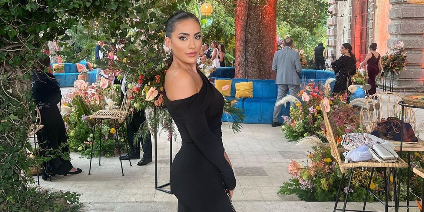 Love Is Blind season 7 Nina zafar in a black outfit posing with people and flowers visible in the background