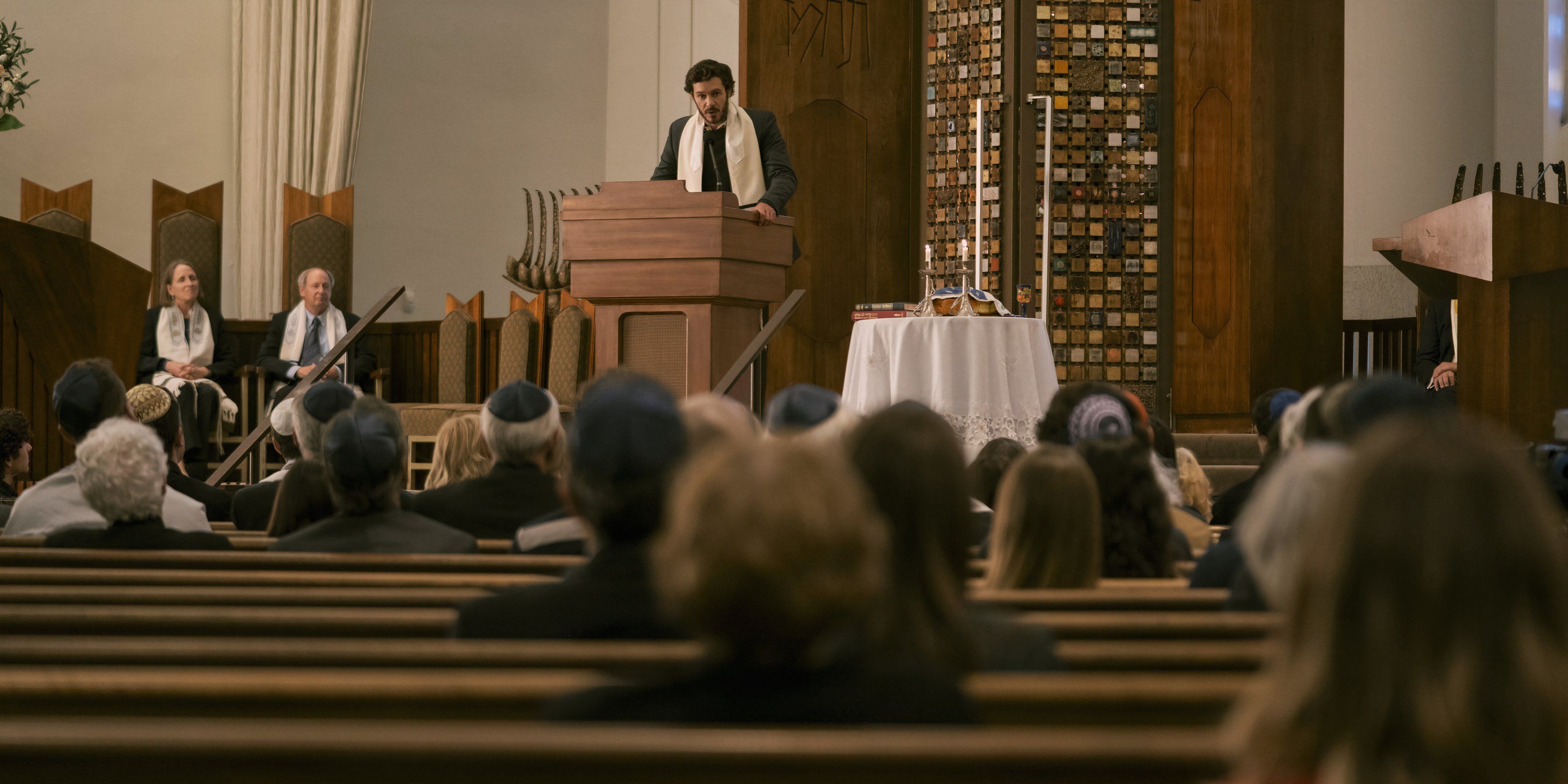 Noah gives a sermon in front of the temple members in Nobody Wants This.