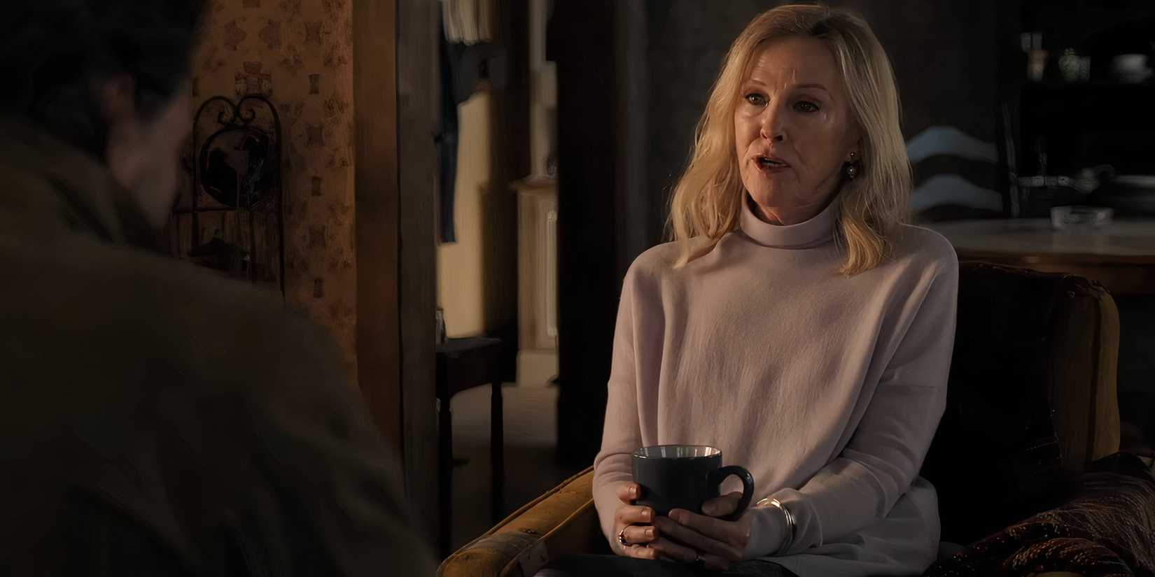 Catherine O'Hara holding a mug while talking to Joel in The Last of Us season 2