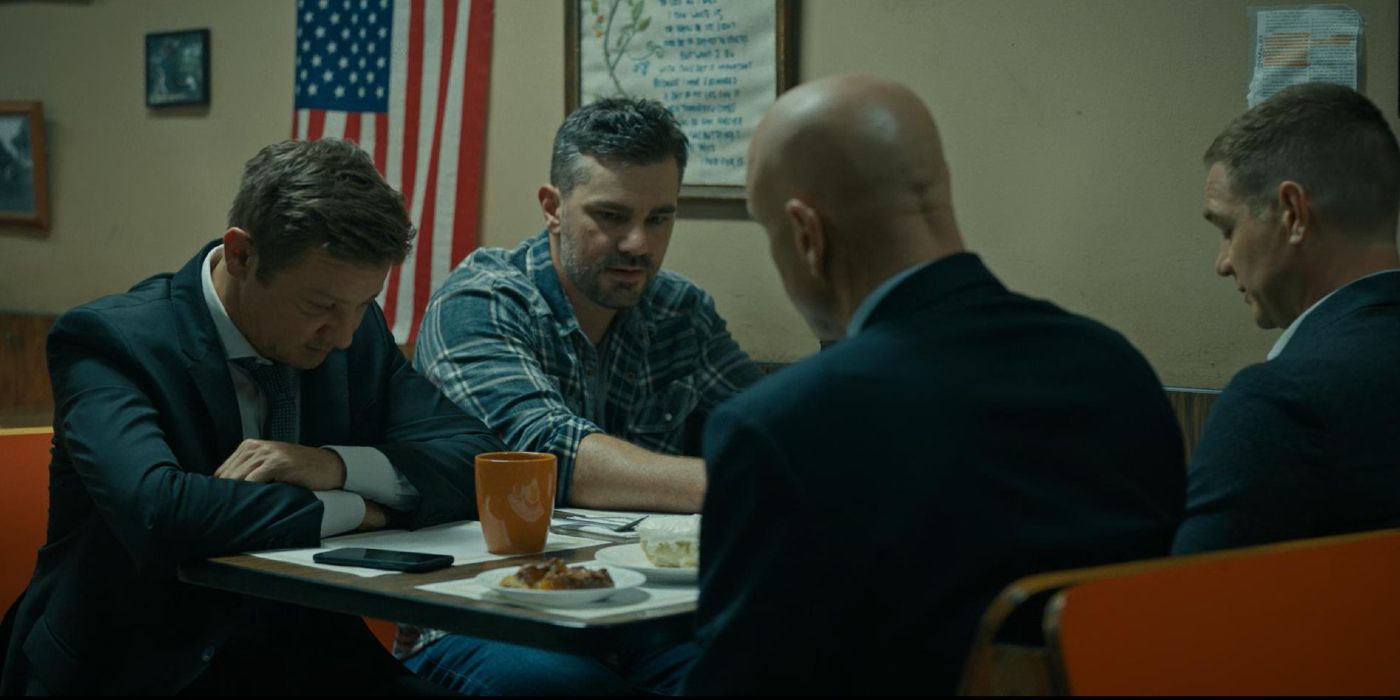 Robert (Hamish Allan-Headley) conversando com Mike (Jeremy Renner) e outros dois policiais sobre a Carta de Ataque Cardíaco em Prefeito de Kingstown.