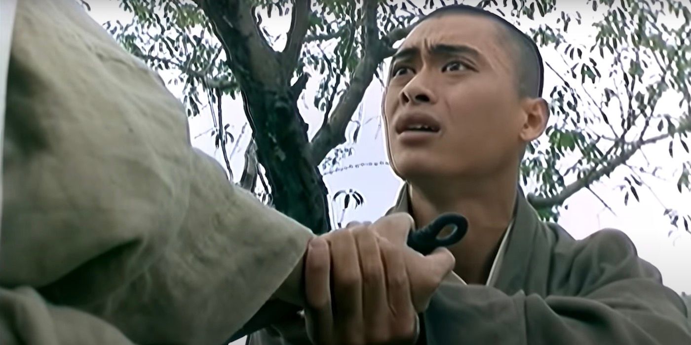 Siu-Wong Fan holds a monk's hand and has a desperate look on his face.