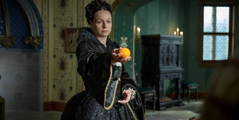 Still from The Serpent Queen series. Catherine holding an orange