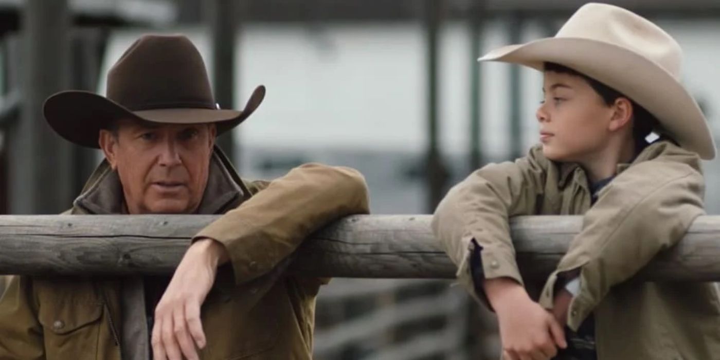 Tate (Brecken Merrill) looking at John (Kevin Costner) from behind a fence in Yellowstone.