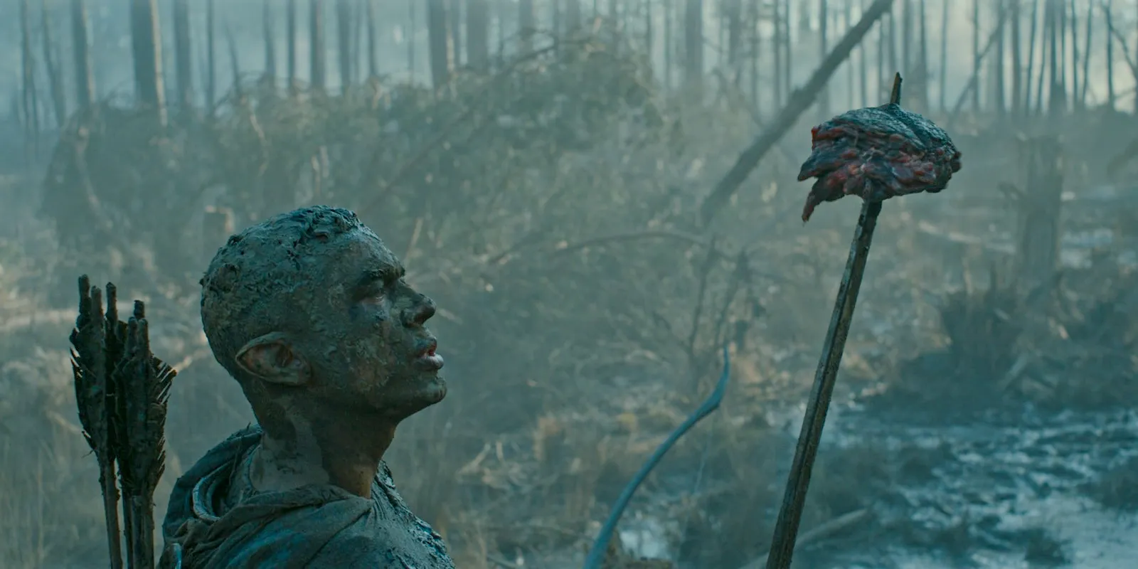 Arondir (Ismael Cruz Córdova) covered in mud with the heart of the swamp monster on his sword in The Lord of the Rings: The Rings of Power Season 2 Episode 4