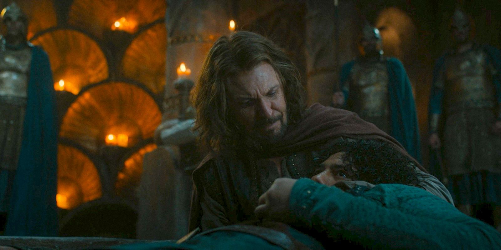 Captain Elendil (Lloyd Owen) witrh Valandil in his arms as he is about to die in The Lord of the Rings: The Rings of Power Season 2 Episode 5