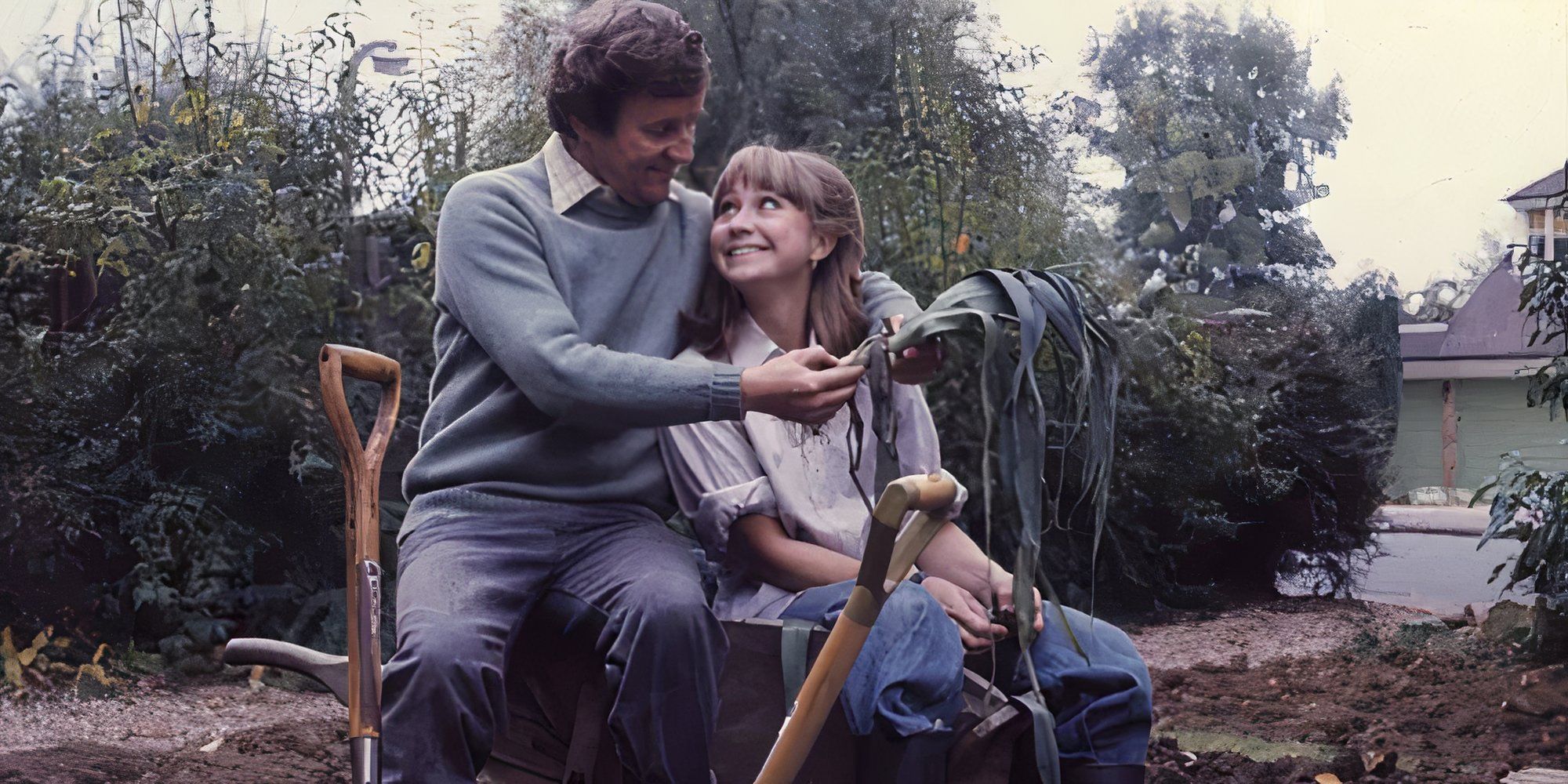 Richard Briers and Felicity Kendal as Tom and Barbara Good smiling and hugging while gardening in The Good Life.