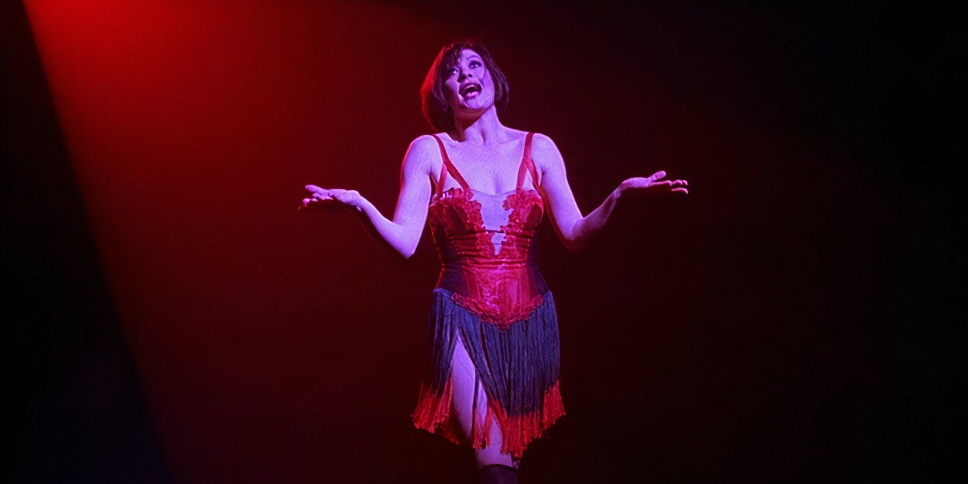 Catherine Zeta-Jones as Velma Kelly in a red showgirl outfit and performing "I Can't Do It Alone" in Chicago.