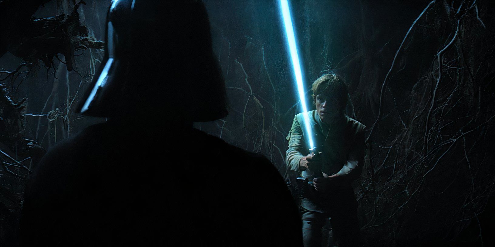 Luke Skywalker (Mark Hamill) brande seu sabre de luz azul contra uma aparição de Darth Vader na Caverna do Mal em Dagobah em O Império Contra-Ataca