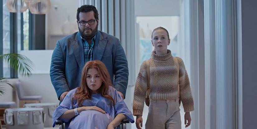 Gary (Josh Gad) wheels Mary (Isla Fischer) through the hospital while Emma (Ariel Donoghue) looks on in concern in Wolf Like Me