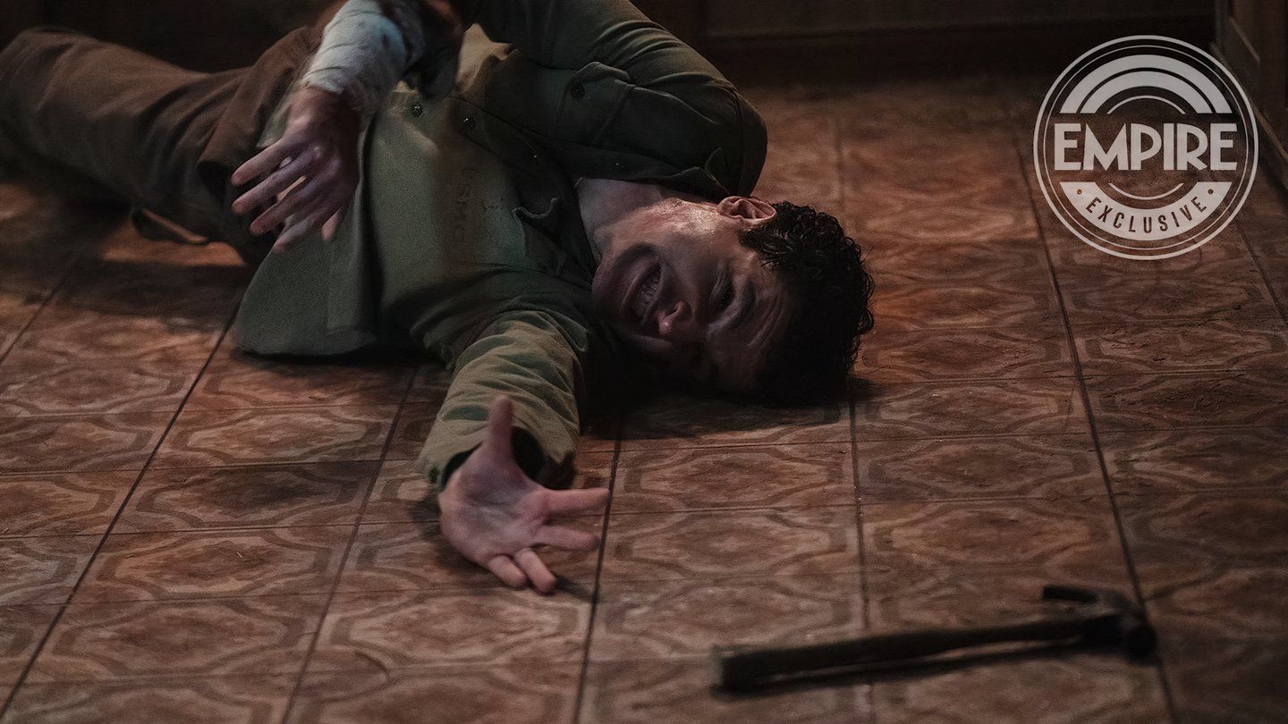 Christopher Abbott reaching for a hammer on the ground as Blake in Wolf Man