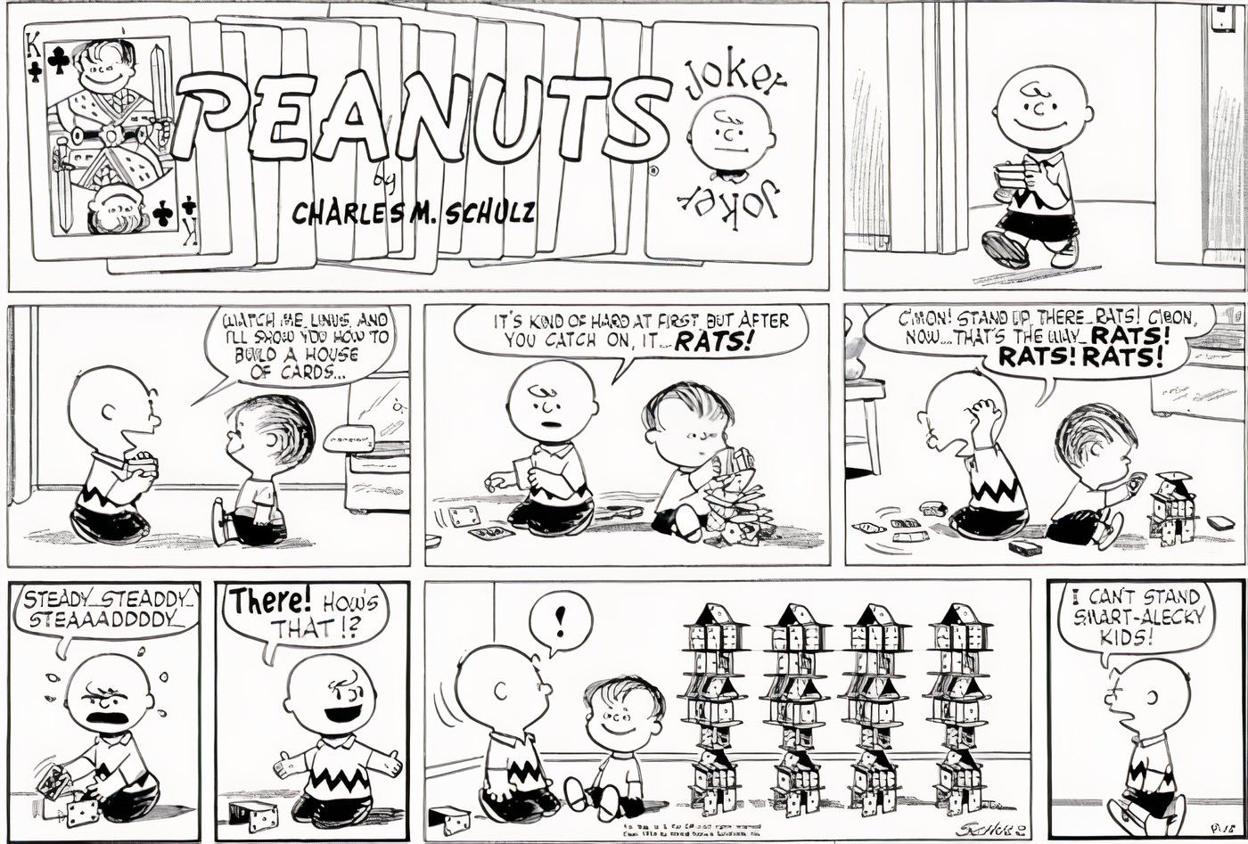 Charlie Brown and Linus building houses of cards.