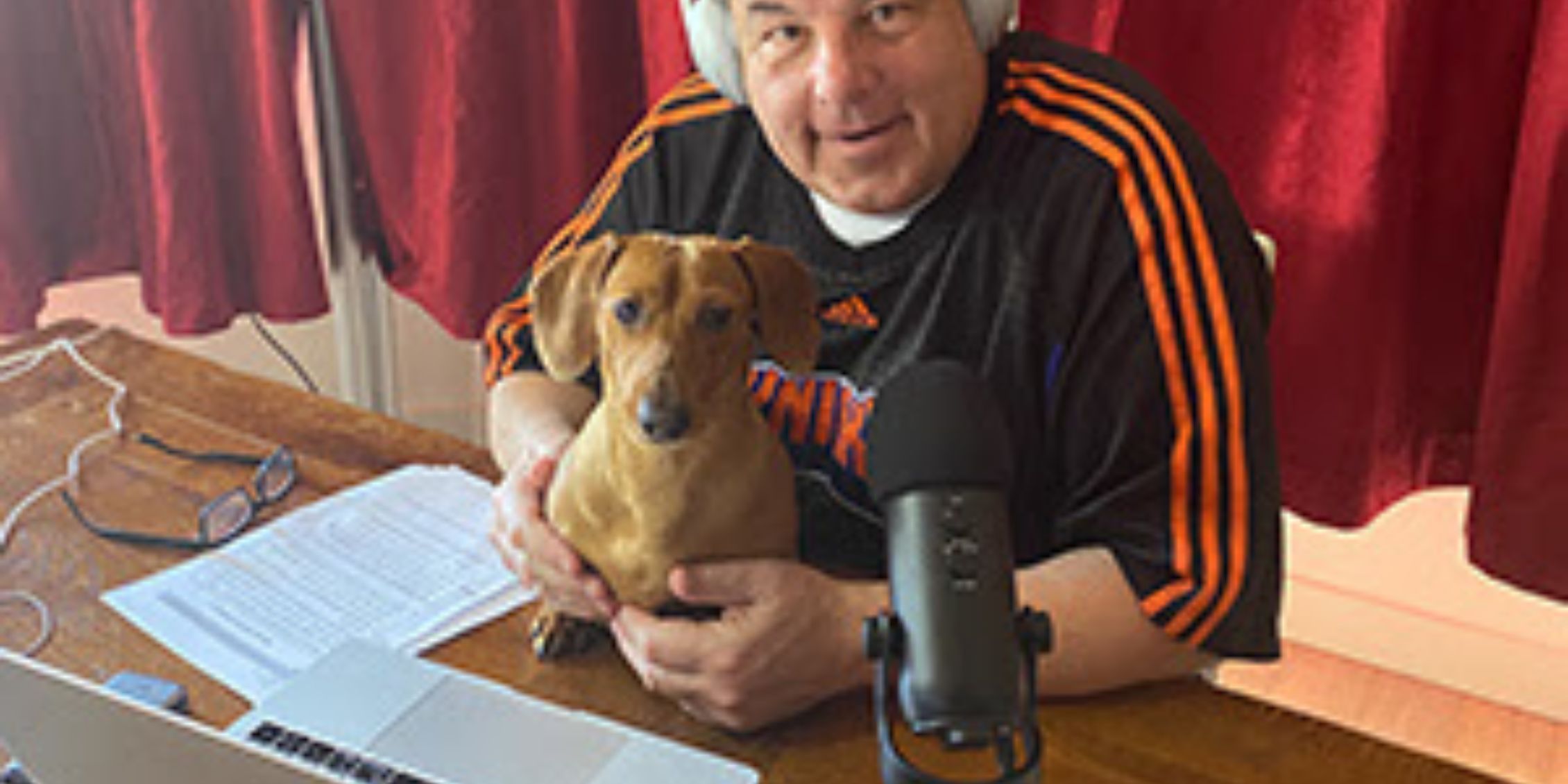 Blue Bloods actor Steve Schirripa sitting at a desk with headphones and microphone holding Willie Boy