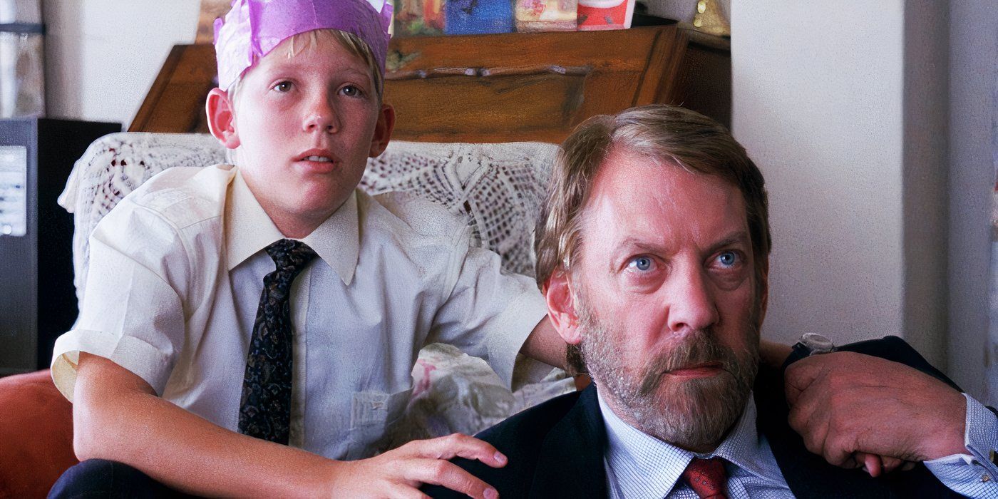 A Dry White Season (1989) Donald Sutherland Plays Den Du Toit with his son with a party hat looks like they are looking at the TV in the distance