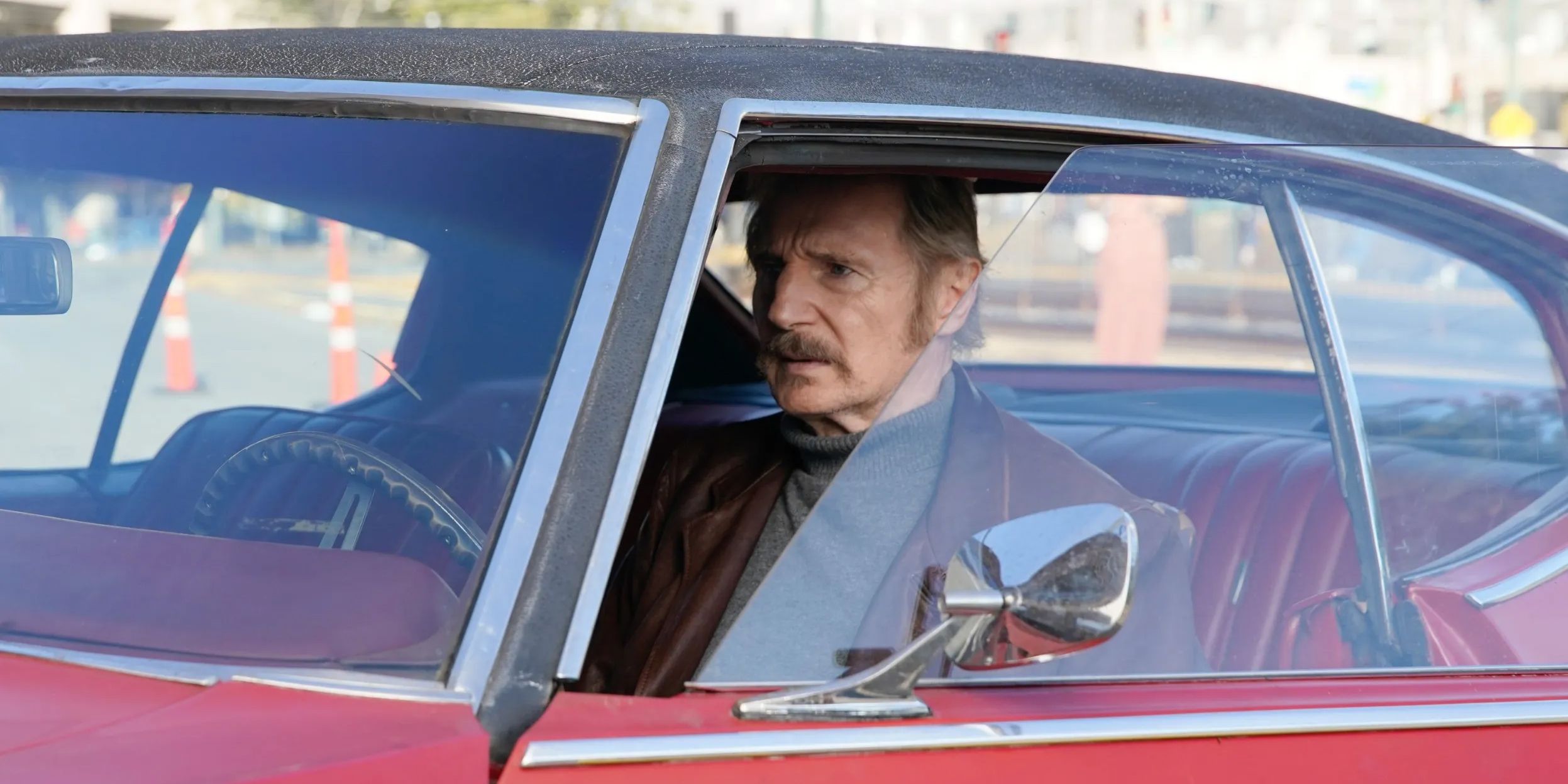 Liam Neeson drives a car with the windows down in Absolution