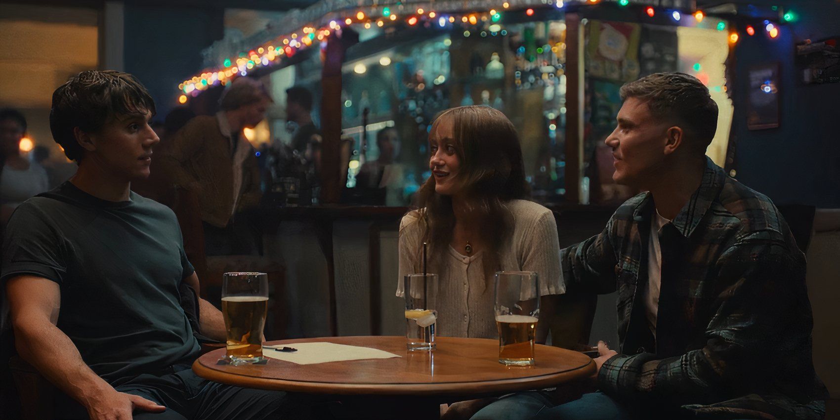 AJ (Calam Lynch), Rhiannon (Ella Purnell), and Craig (Jon Pointing) sitting at a pub in Sweetpea episode 4