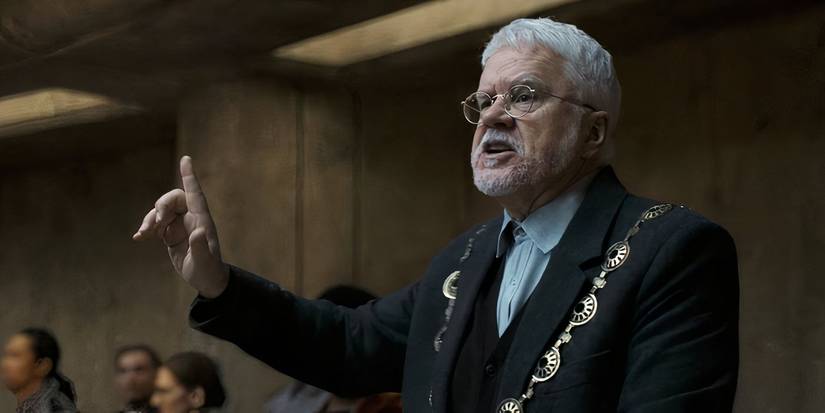 Bernard talks to a crowd of people inside the silo in Silo season 2