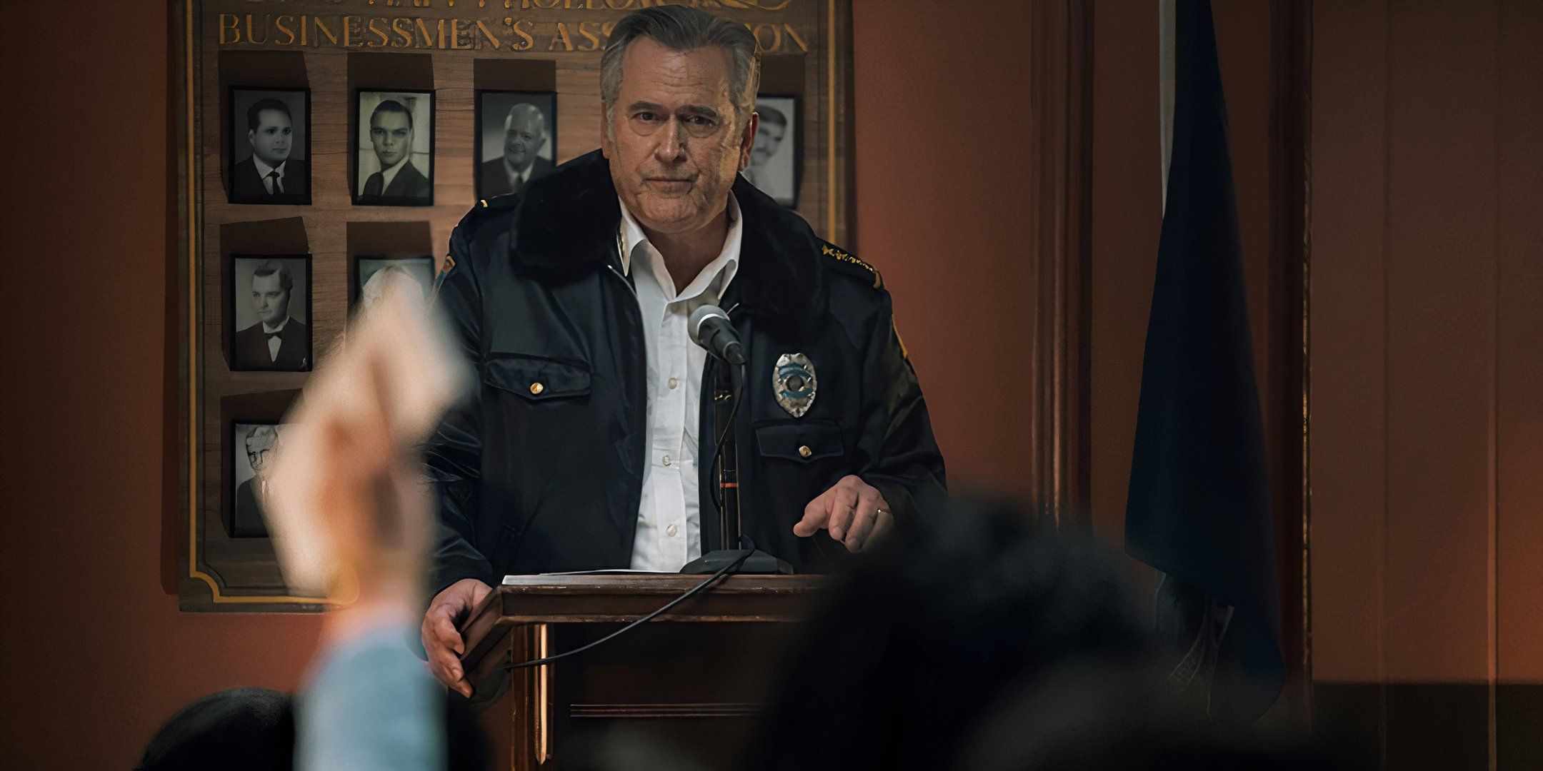 Bruce Campbell as Chief Dandridge looks unhappy during a press conference in Hysteria