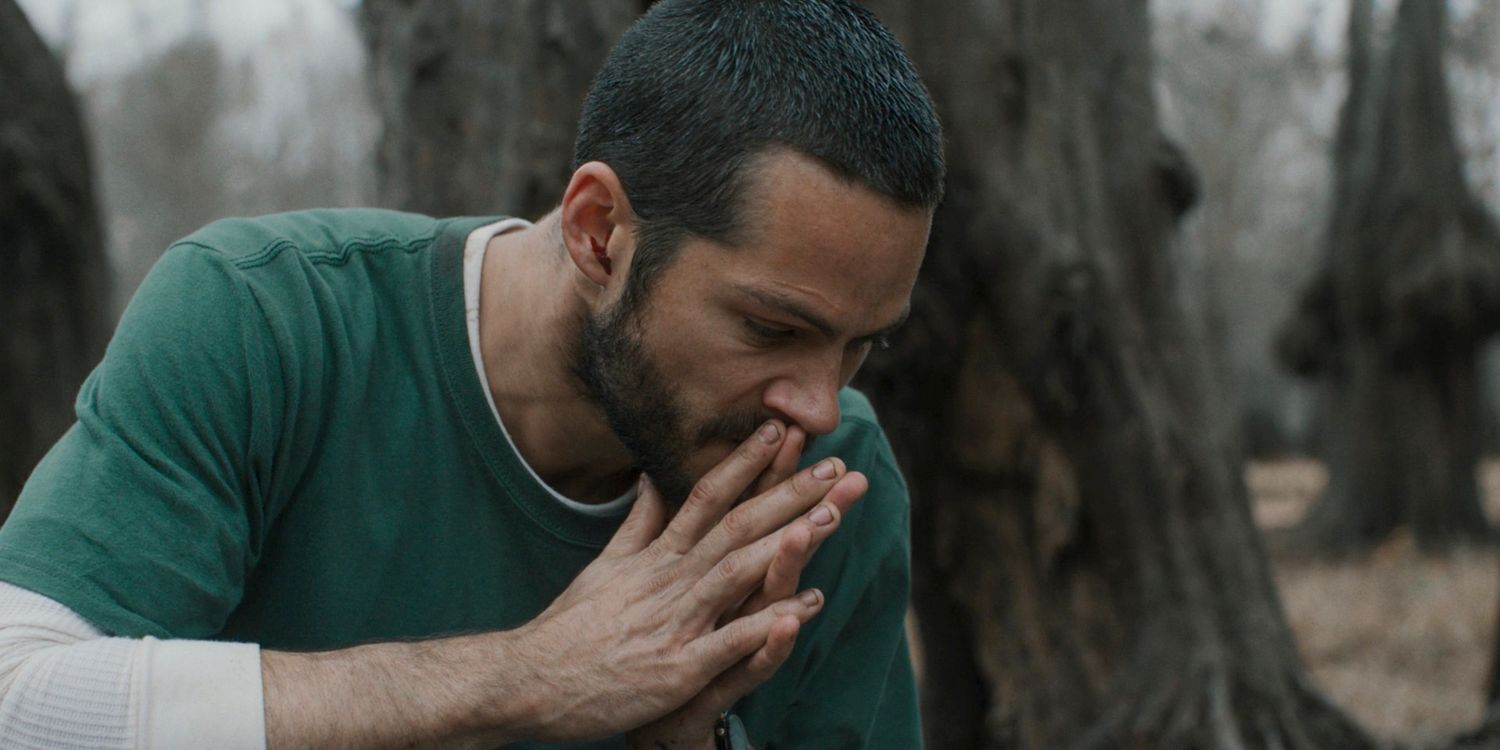 Dylan O'Brien with his hands in front of his face in Caddo Lake