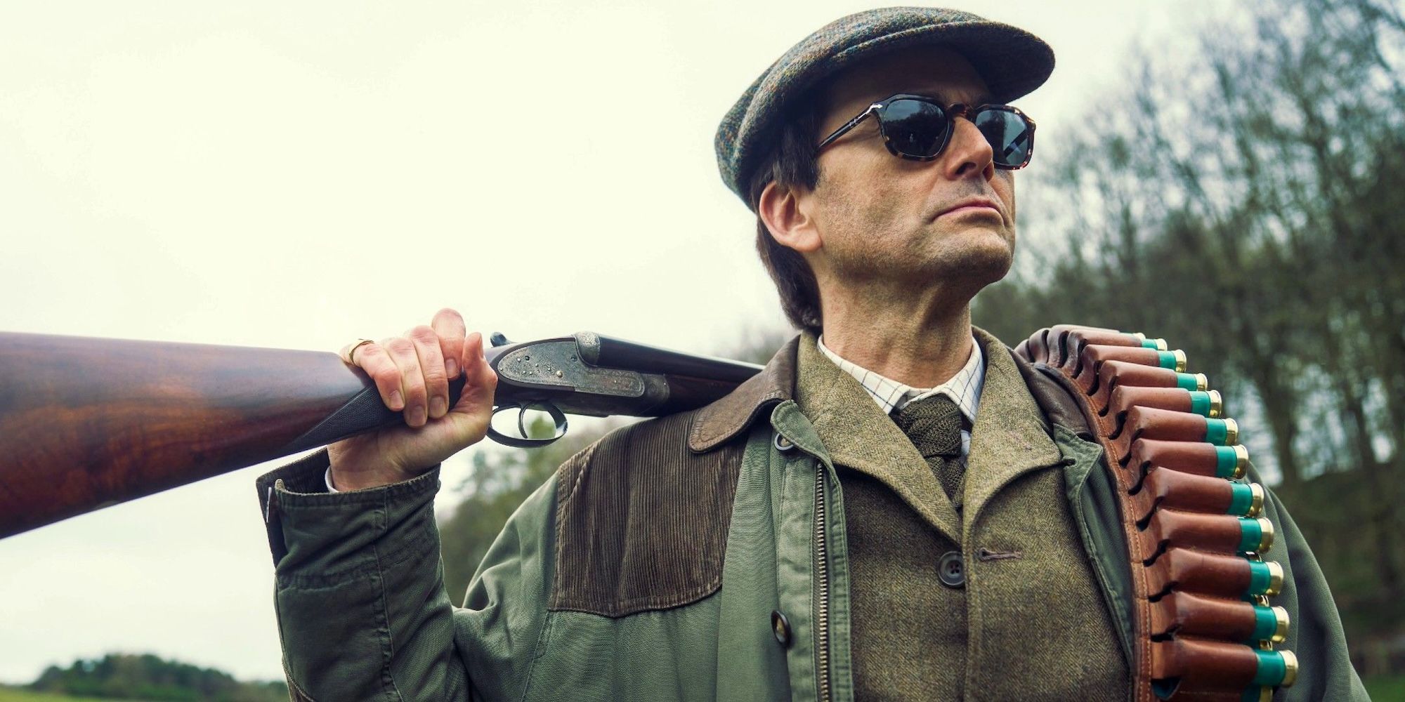 David Tennant with a rifle resting on his shoulder in Rivals