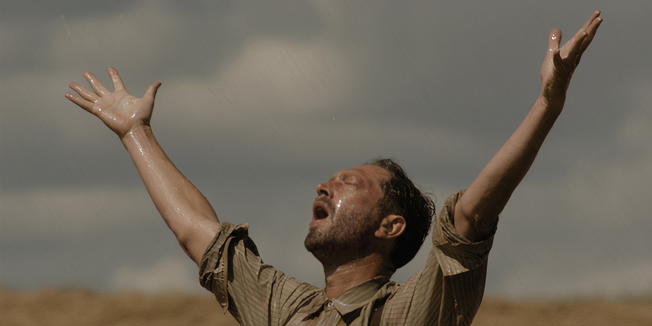 Ebon Moss-Bacharach as Wallace with his mouth open, eyes closed and arms raised toward the sky in a rainstorm in Hold Your Breath