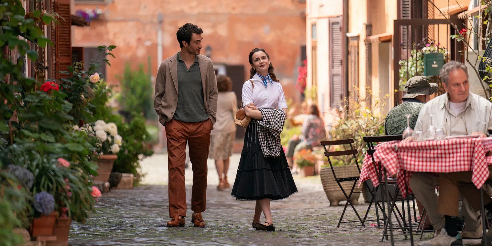 Emily in Pari's main character Emily walking with her love interest, Marcello, through a city street of Rome. 