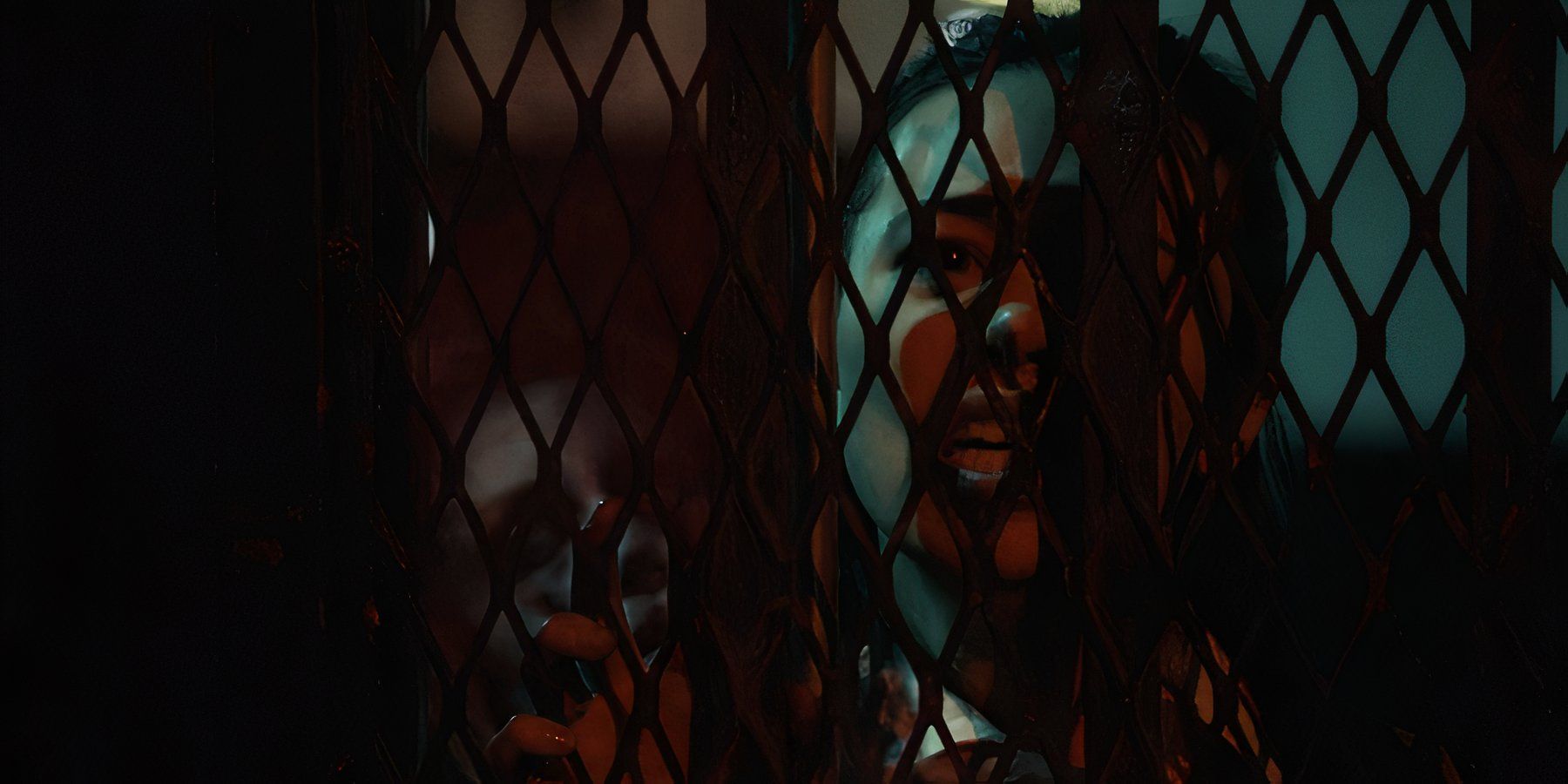 Woman in horror film All Hallows' Eve: Inferno trapped behind a fence.