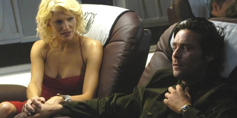 Gaius Baltar and Number Six sitting in comfy seats in Battlestar Galactica.