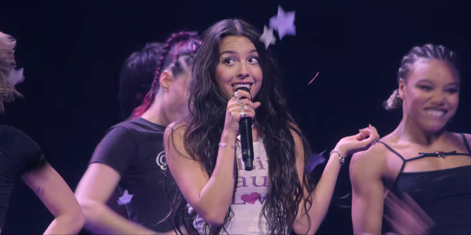 Olivia Rodrigo Smiling While Performing "Get Him Back!" In Netflix's Olivia Rodrigo: GUTS World Tour