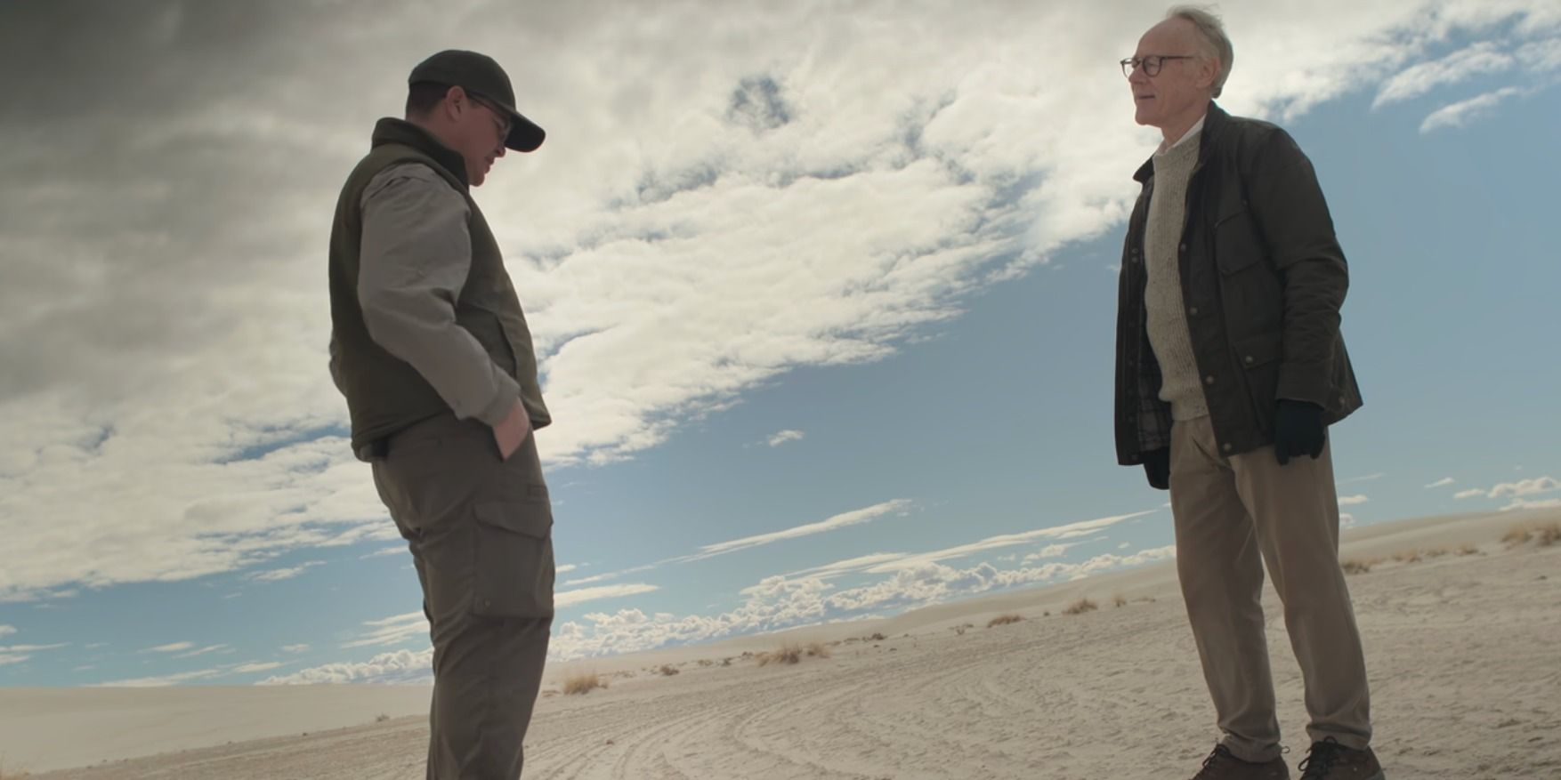 Graham Hancock Ancient Apocalypse speaking to someone while standing on the white sands